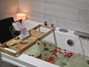 a bottle of wine in a bath tub with a sign in it at Apartament w Centrum z wanną z hydromasażem in Kętrzyn +35 photos