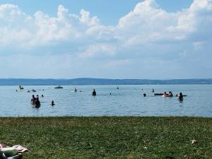 a group of people swimming in a large body of water at Silver Harmony Apartman Siófok in Siófok