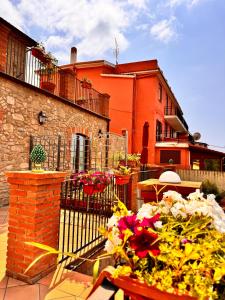 a building with a fence and a table with flowers at B&B Antico Casale in Fuscaldo