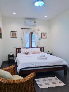 Un dormitorio con una cama con dos sillas y una ventana. en 1 Bedroom House With Pool In Central Location, en Hua Hin