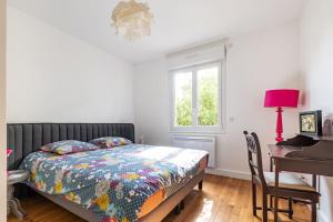 ein Schlafzimmer mit Bett, Schreibtisch und Fenster in der Unterkunft Paris La Defense - Refurbished independent house in La Garenne-Colombes