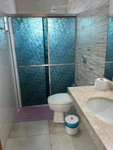 une salle de bains avec douche, toilettes et lavabo dans l'établissement Flat Piúva, à Bonito