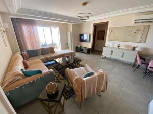 a living room with a couch and chairs and a table at Panorama Apartment Zone Touristique Haut Standing in Mahdia