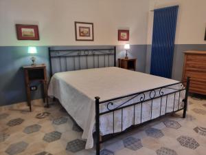 a bedroom with a bed and two tables and a dresser at Le Gatte Rosa B&B in Bevagna