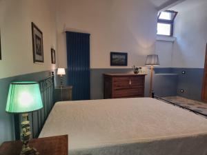 a bedroom with a bed with a lamp and a window at Le Gatte Rosa B&B in Bevagna