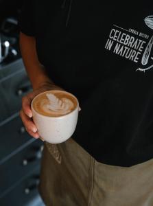 a person is holding a cup of coffee at Slow Tatry Boutique Resort&SPA in Zakopane