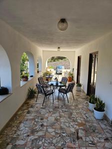 a patio with a table and chairs on a stone floor at Casa Sabrina in Lipari