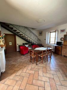 a living room with a table and chairs and a staircase at Ca' Rivella - paceful country living in Villa dʼAiano