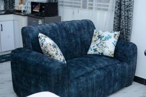 a blue chair with a pillow in a living room at Dondoo Homes Kilifi in Kilifi