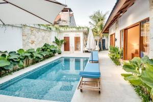 レギャンにあるVilla Mayoの椅子2脚とパラソルを備えた屋外プール