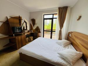 a bedroom with a bed and a tv and a window at Ski Chalet Sinaia in Sinaia