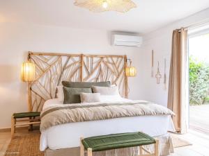 a bedroom with a large bed with a wooden headboard at Be Happy à pied de Friar's Bay face au coucher de soleil in Friar's Bay