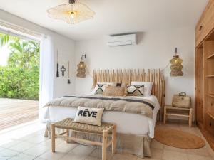 a bedroom with a bed with akeep sign on it at Be Happy à pied de Friar's Bay face au coucher de soleil in Friar's Bay