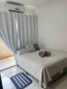 a bedroom with a bed with a curtain at Apartamento Doce Lar in Dourados