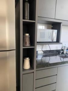 a kitchen with a refrigerator and a microwave at Apartamento Doce Lar in Dourados +26 photos