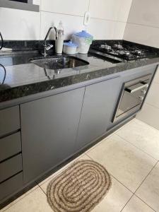 a kitchen with a sink and a counter top at Apartamento Doce Lar in Dourados
