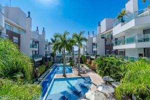 an image of a swimming pool at a resort at Apartamento em Condomínio com Piscina e Jacuzzi - Boulevard Bombinhas in Bombinhas