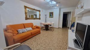 a living room with an orange couch and a table at La Explanada in Alicante