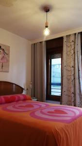 a bedroom with a large bed with an orange blanket at La Explanada in Alicante
