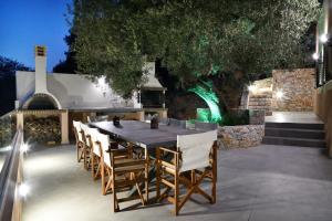 a dining table and chairs on a patio at night at Alexandras's Mansion - Alexinia's House in Ayiá