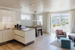 eine Küche und ein Wohnzimmer mit Tisch und Stühlen in der Unterkunft Bäum Hüs A in Westerland