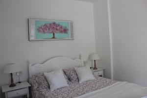 sypialnia z białym łóżkiem i zdjęciem drzewa w obiekcie Mi apartamento Mini 2 w mieście Puerto Naos