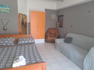 una sala de estar con un sofá y una silla en Budget Cozy, en Pula