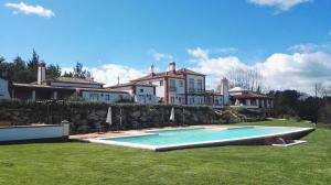 a house with a swimming pool in front of a house at Hotel Rural Monte da Provença in Elvas
