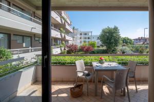 patio ze stołem i krzesłami na balkonie w obiekcie Il Sogno Apartments w mieście Desenzano del Garda