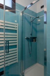 łazienka z prysznicem z niebieskimi kafelkami w obiekcie Il Sogno Apartments w mieście Desenzano del Garda