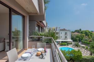 a balcony with a table and chairs and a pool at Il Sogno Apartments in Desenzano del Garda