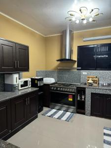 a kitchen with black cabinets and a stove top oven at MDEC Apartments in Hilongos