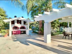a white house with a porch and a patio at Pupillo Casa Vacanza in Francavilla Fontana +14 photos