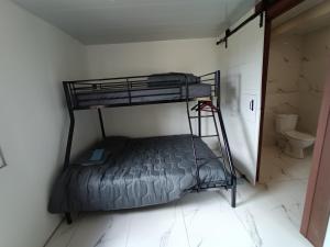 a bunk bed in a room with a toilet at Soleil levant au domaine de Tara in LʼHôpital-du-Grosbois