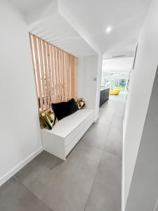 a room with a white couch and a window at Villa d'Exception avec piscine & spa à Mérignac - Aeroport - Tram direct centre - Aéroparc Business Center Mérignac - Airbus Thales Safran - Hôpital Charles Perrens - Hôpital Pellegrin - ZI Espace Mérignac Phare in Mérignac