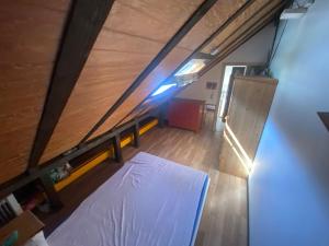 Camera mansardata con materasso su pavimento in legno. di Ilir-home a Baden