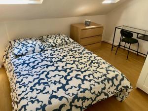 a bedroom with a bed with a blue and white comforter at Beach à Bâbord - plage 400m, 4 Personnes, Le Havre in Le Havre