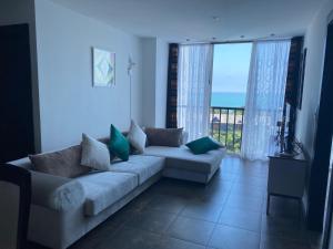 a living room with a couch and a view of the ocean at Punta Centinela Apartment in Punta Blanca +26 photos