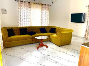a living room with a yellow couch and a table at Minty Homestay in Perumanseri