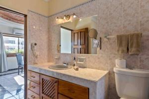 een badkamer met een wastafel, een toilet en een spiegel bij Apartments Olas Altas Romantic Zone of Puerto Vallarta in Puerto Vallarta +37 foto's