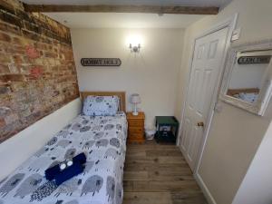 a bedroom with a bed and a brick wall at Salisbury Guest House - free parking in York