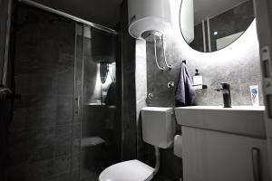 a bathroom with a toilet and a sink and a mirror at Apartman Lamela in Zenica +27 photos