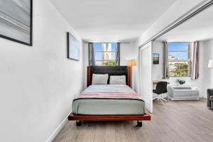 une chambre avec un lit dans une pièce avec des fenêtres dans l'établissement Deluxe modern 1 bedroom in south beach, à Miami Beach