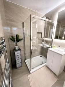 ein Badezimmer mit Dusche und Waschbecken in der Unterkunft Modern 2 bed near mall and parking in Golders Green