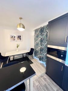 ein Wohnzimmer mit einem Tisch und einem großen TV in der Unterkunft Modern 2 bed near mall and parking in Golders Green