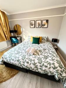 Schlafzimmer mit einem Bett mit einer grünen und weißen Bettdecke in der Unterkunft Modern 2 bed near mall and parking in Golders Green