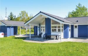 una casa azul con una mesa de picnic en un patio en Three-Bedroom Holiday Home In Orsted, en Ørsted 15 fotos más