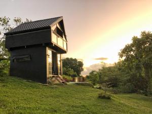 a small black house on a grassy field at Garden of Faith Lodge - 20 minutes drive from Tagaytay in Calaca