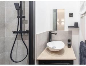 een badkamer met wastafel en douche bij Cocon design et cosy à La Défense, vue imprenable sur Paris in Puteaux +9 foto's
