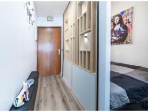 een slaapkamer met een bed en een houten deur bij Cocon design et cosy à La Défense, vue imprenable sur Paris in Puteaux